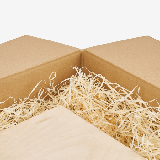 Kartonverpackung, gefüllt mit Holzwolle, die den Inhalt vor Beschädigungen schützt.